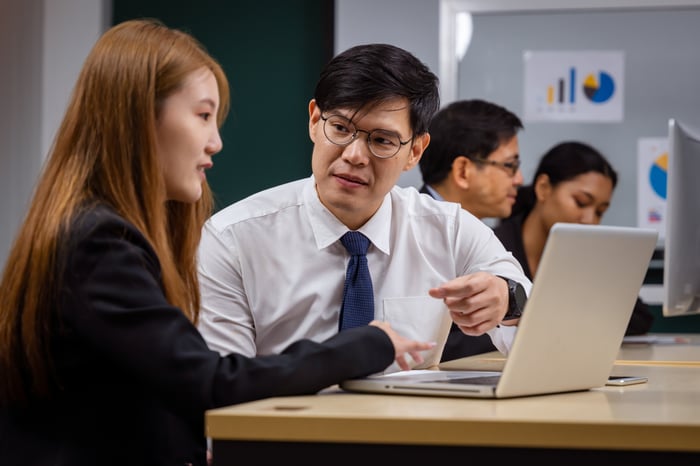 Team members discussing personalized HubSpot Training with laptop support